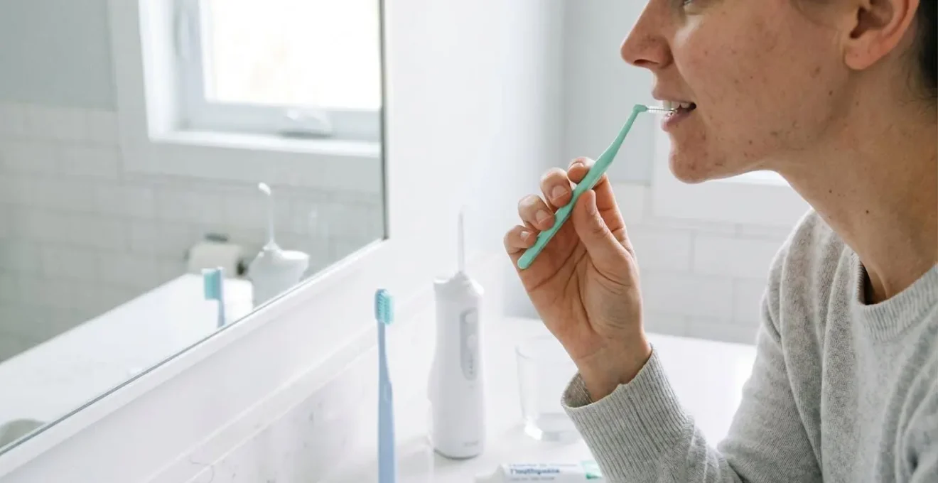 Brossettes interdentaires, brosse souple, fil dentaire et hydropulseur pour entretien quotidien des implants dentaires sur surface blanche épurée